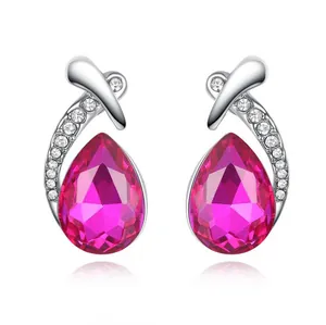 Close-up of elegant teardrop crystal earrings with pink gemstones and rhinestones
