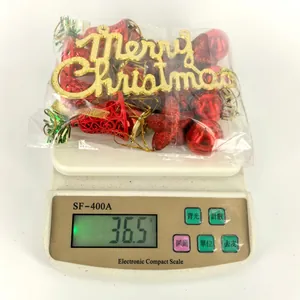 Primer plano de adornos navideños rojos pesados en una báscula que indica 36,5 gramos