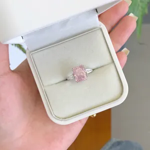 Gros plan d'une bague élégante avec zircone rose dans un écrin de bijoux en velours blanc