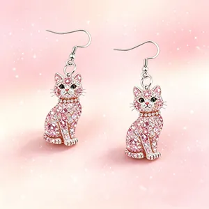 Close-up of pink crystal cat-shaped hook earrings with sparkling gem details.