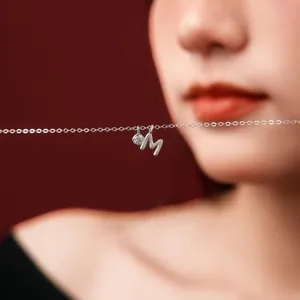 Close-up of S925 sterling silver necklace with letter M pendant and small crystal