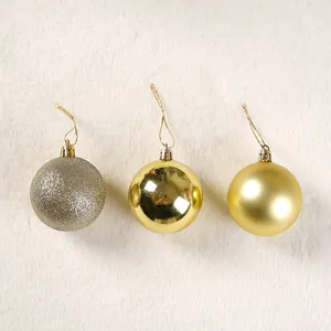 Primo piano di palline di Natale dorate con finiture glitterate, lucide e opache