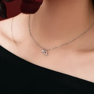 Close-up of a dainty S925 sterling silver necklace with zircon and letter 'a' pendant