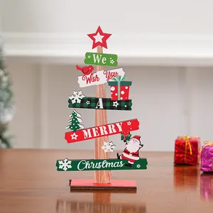 Vista detallada de un letrero de madera para mesa con forma de árbol de Navidad y mensaje festivo