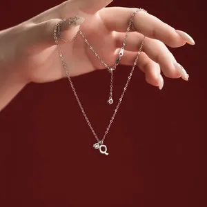 Close-up view of S925 sterling silver necklace featuring a letter Q pendant and crystal