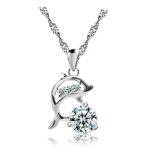 Detailed macro view of silver dolphin pendant necklace with clear sparkling crystals
