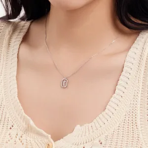 Close-up view of a delicate S925 sterling silver necklace with an initial E pendant on a model.