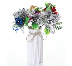 Tiges de Noël artificielles avec pommes de pin argentées et baies dans un vase blanc