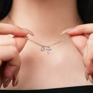 Close-up of a S925 sterling silver necklace with dainty initial T and gem charms