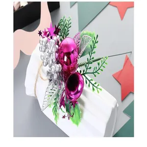 Détail d'une tige de Noël avec boules roses, baies argentées et feuillage vert
