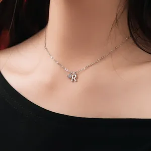 Close-up of S925 sterling silver necklace featuring a letter R and sparkling stone.