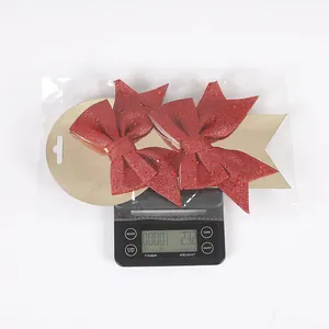 Lazos de Navidad rojos con purpurina en una báscula digital que pesa 23,2 gramos