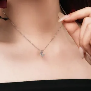 Close-up of elegant S925 sterling silver necklace with letter V pendant on a woman.