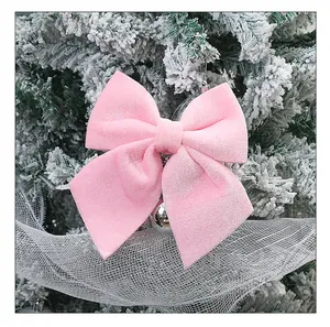Prachtige detailopname van een roze fluwelen strik aan een besneeuwde kerstboom.