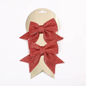Primer plano de dos lazos rojos brillantes de Navidad en tarjeta dorada para decoración