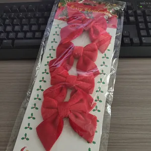 Gedetailleerde opname van vier rode fluwelen kerststrikken in een transparante plastic verpakking.