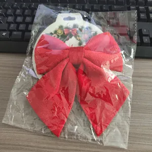 Detail van een grote rode fluwelen kerststrik in de originele doorzichtige verpakking