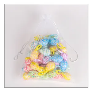 Colorful fabric-covered foam Easter eggs with hanging ribbons in white mesh drawstring bag