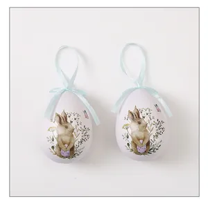 Primer plano de adornos colgantes de huevos de Pascua blancos con dibujo de conejo