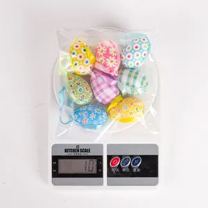 Eight colorful fabric-wrapped Easter eggs weighed at 10 grams on a digital scale