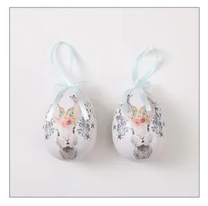 Huevos de Pascua decorativos con dibujos de conejo y flores, cinta de seda azul