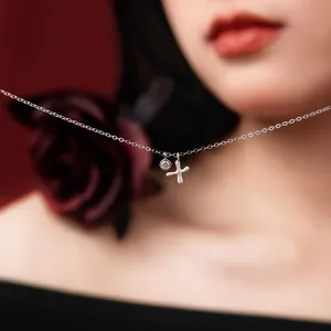 Macro detail of refined S925 sterling silver necklace with dainty letter X pendant