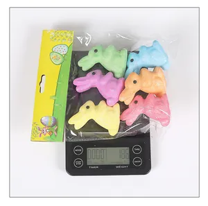 Close-up view of 6 colorful foam glitter Easter bunnies on a digital scale showing 18.6g weight