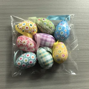 Detailed view of 8 colorful fabric-covered Easter egg ornaments in clear packaging