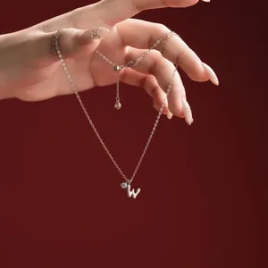 Close-up of S925 sterling silver necklace featuring a 'W' initial pendant and crystal