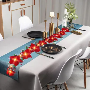Detailansicht der roten Weihnachtsstern-LED-Lichterkette auf einem festlich gedeckten Tisch