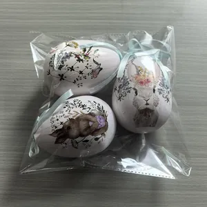 Vista detallada de tres huevos de Pascua de espuma con estampados de conejos en una bolsa