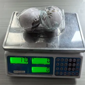 Vista detallada de dos huevos de Pascua florales pesados en una balanza digital de 11,0 g