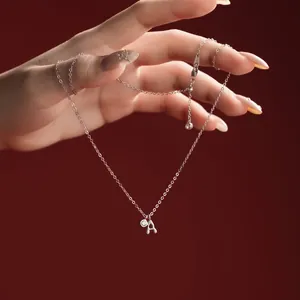 Detailed macro view of S925 sterling silver necklace with letter A pendant held by hand