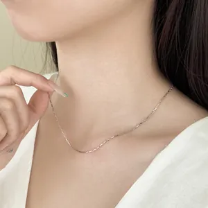 Primer plano de un delicado collar de plata de ley 925 en el cuello de una modelo