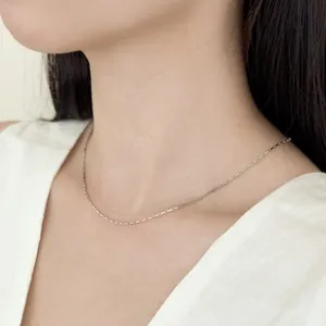 Vista detallada de un collar de cadena minimalista de plata de ley S925 usado por modelo