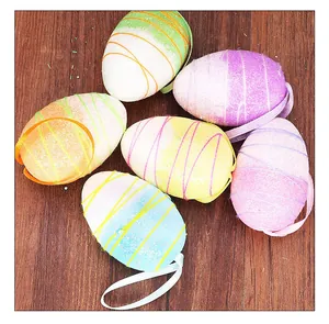 Detailed view of six colorful Easter foam eggs with ribbons on a wooden surface.