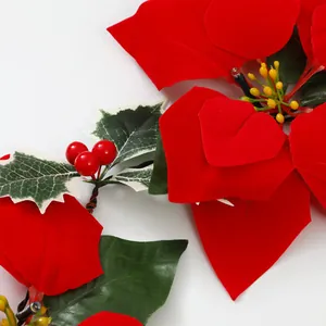 Nahaufnahme von roten Weihnachtssternen aus Samt und grünen Stechpalmenblättern