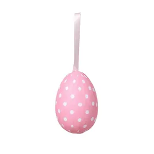 Detailed view of a pink foam Easter egg with white polka dots and a satin hanging ribbon.