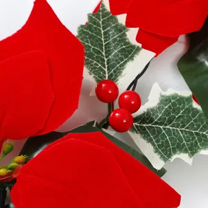 Makrodetail der roten Weihnachtsstern-Blütenblätter und glänzenden Beeren an der LED-Kette
