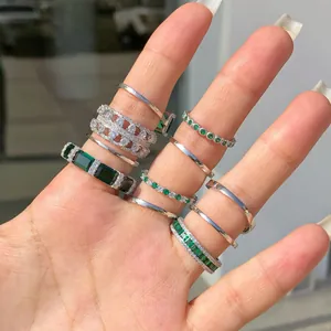 Vista dettagliata di più anelli in argento con zirconi verde smeraldo sulla mano