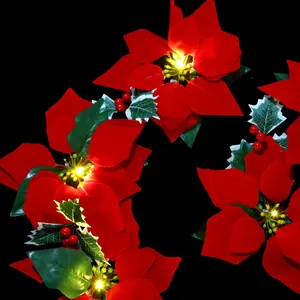 Nahaufnahme der künstlichen Weihnachtsstern-LED-Lichterkette mit roten Beeren