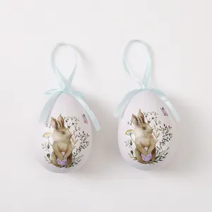 Pareja de huevos de Pascua decorativos con dibujos de conejos y flores con cintas azules