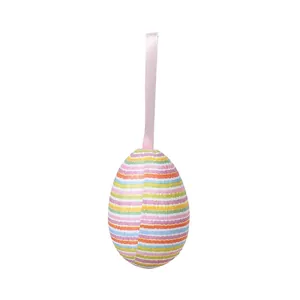 Close-up of a decorative Easter egg featuring vibrant multi-color stripes and pink ribbon