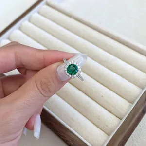 Vista macro di un elegante anello in argento S925 con zircone smeraldo verde sulla mano