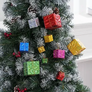 Detailansicht bunter Laser-Geschenkbox-Anhänger an einem verschneiten Weihnachtsbaum