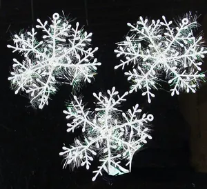 Vista dettagliata di tre decorazioni natalizie a forma di fiocco di neve in plastica bianca