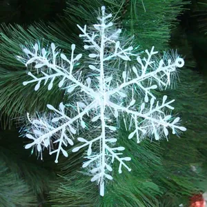 Fiocco di neve in plastica bianca con fibre iridescenti su albero di Natale verde