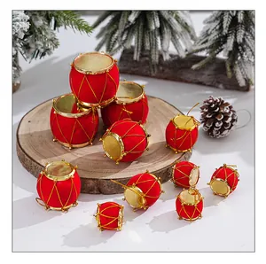 Adornos de tambor de Navidad rojos flocados dispuestos en una rodaja de madera rústica