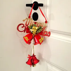 Detail der Weihnachtsglocken-Aufhängung mit roter Schleife und goldenem Merry Christmas-Schild