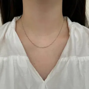 Vista detallata de un collar minimalista de plata de ley S925 en una modelo mujer